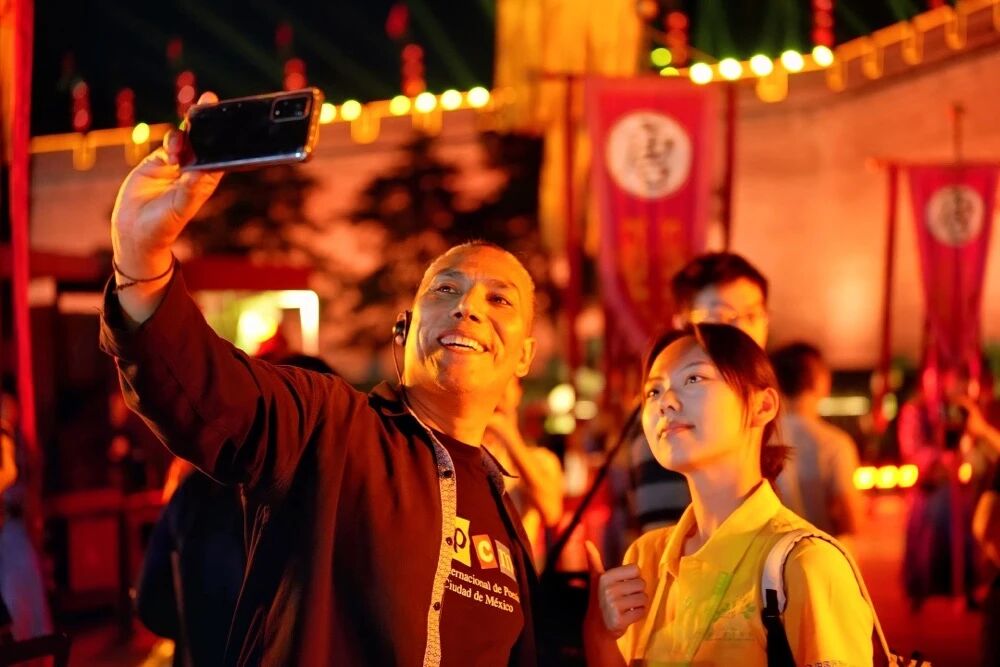 参加2025国际青春诗会的拉美诗人和中国诗人在西安永宁门观看欢迎仪式。图为墨西哥诗人马努艾尔·夸乌特勒在欢迎仪式后与志愿者合影